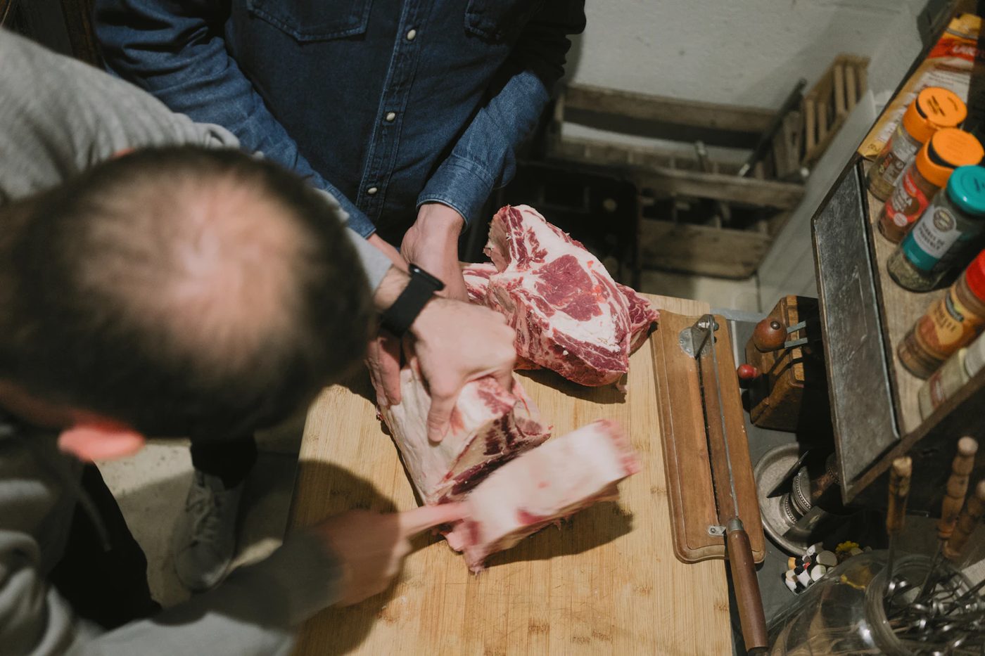 Carnicero preparando cortes de res en tabla de madera — La Carnicerie