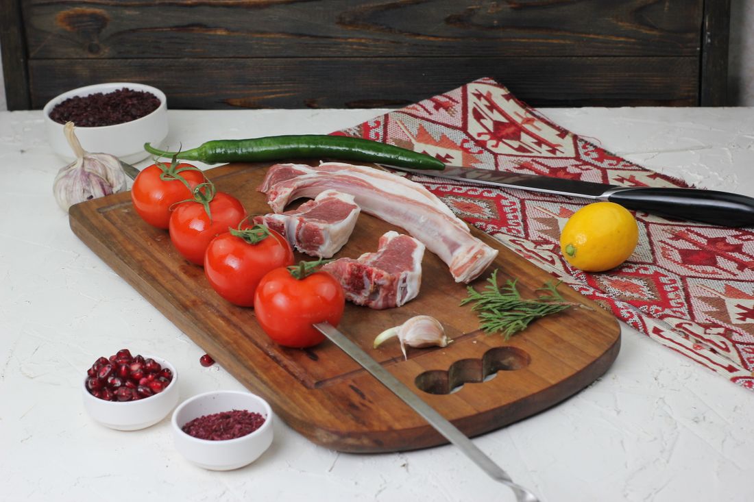 Cortes de cordero: chuletas y costillar sobre tabla de madera – La Carnicerie