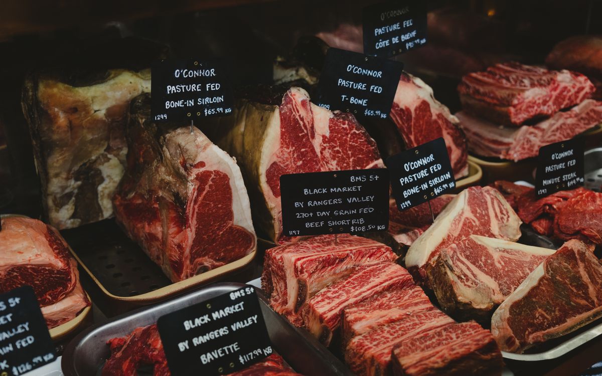 Vitrina de carnicería con cortes premium — guía de cuánta carne por persona