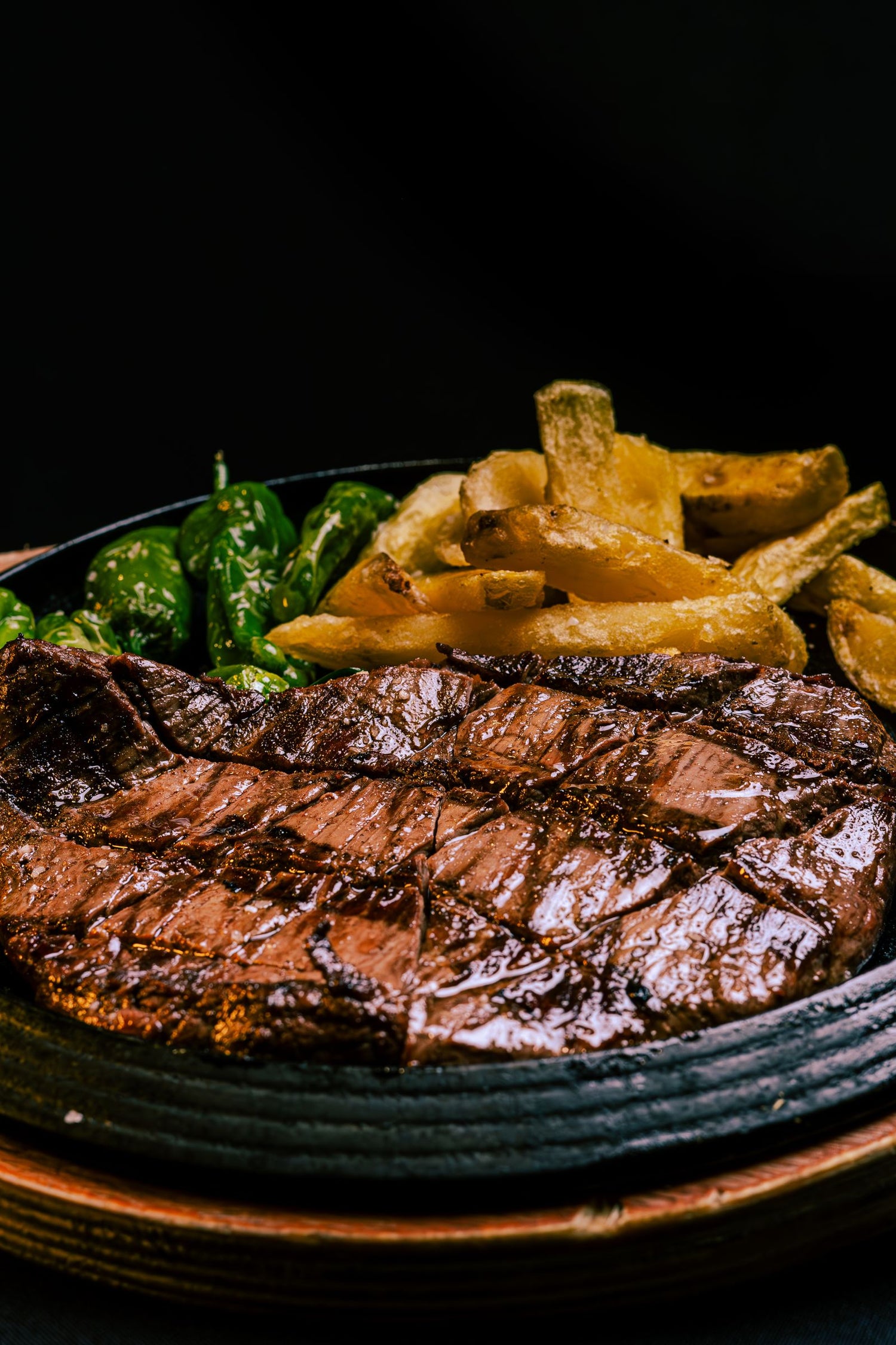 Entraña a la parrilla servida con pimientos y papas