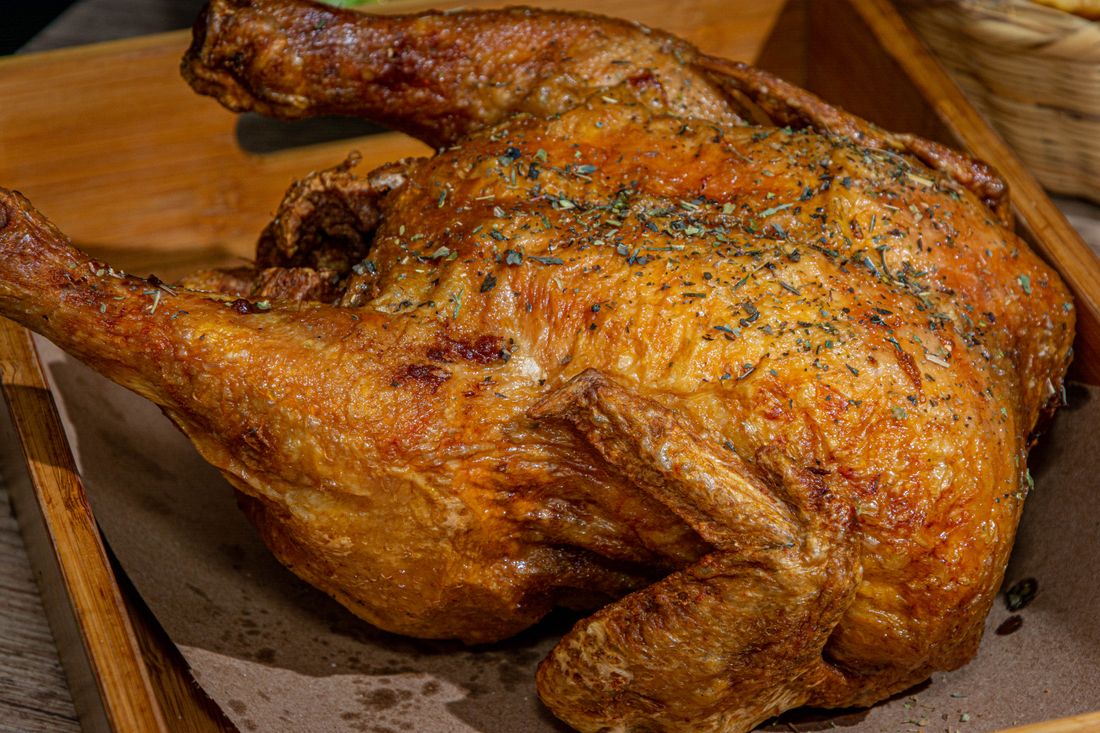 Pollo campesino asado entero con la piel dorada y hierbas