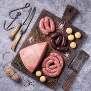 Kit Asado de Punta de Anca: punta de anca entera, chorizo, morcilla y arepitas sobre tabla de madera, La Carnicerie